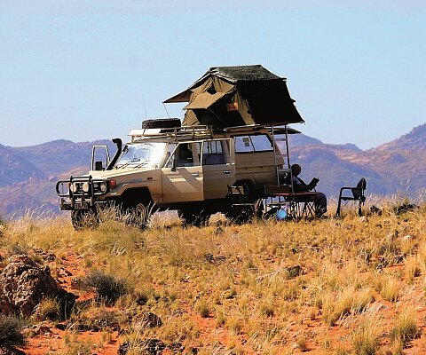 Jeep mit Zeltdach in Namibia Eine Geländewagen mit Zeltdach steht in der Steppe Namibias.
